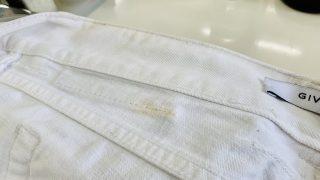 白いデニムパンツのブランド皮革パッチから滲んだ皮革の色移りは染み抜き処理を行う事が可能です