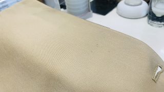 アイボリー綿コートに古そうなシミが付いてるのを触ってしまいますと生地の色が薄くなってしまうかも知れませんよ